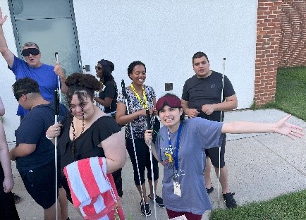 Staff and students with long white canes, ready to go white water rafting.